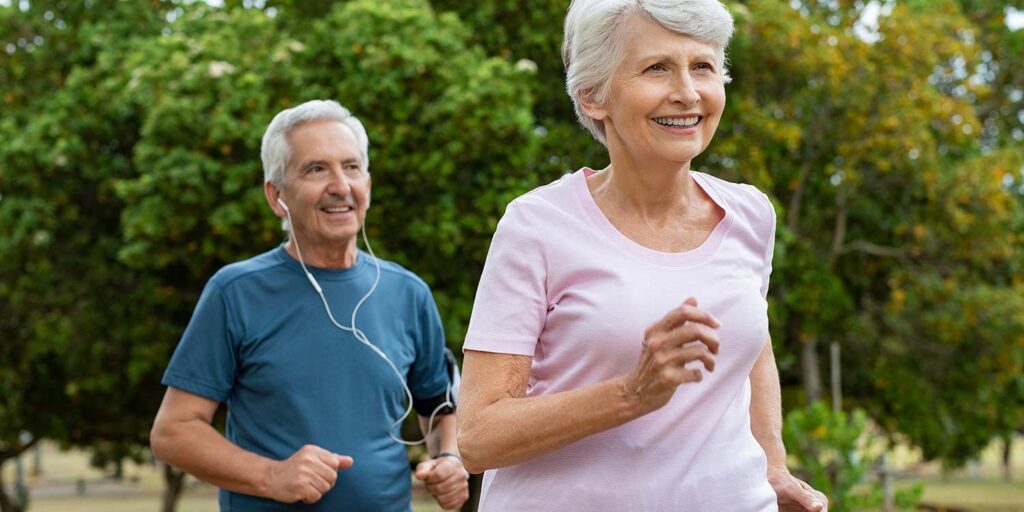 Photo of an elderly man and an elderly woman jogging together, concept of mental health awareness for older adults.